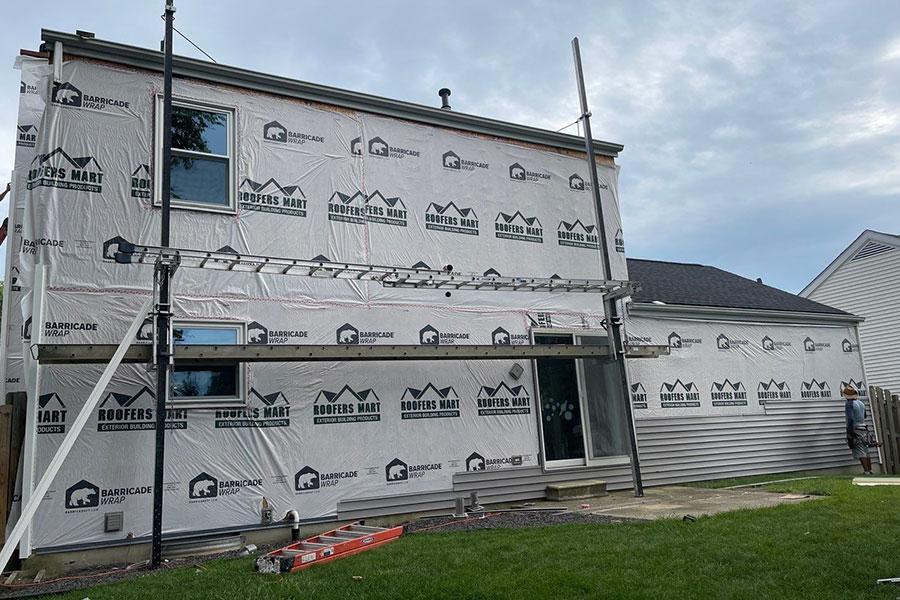 The exterior of a residential home in Springfield, IL that is being covered by house wrap to protect against moisture damage before the vinyl siding is installed.