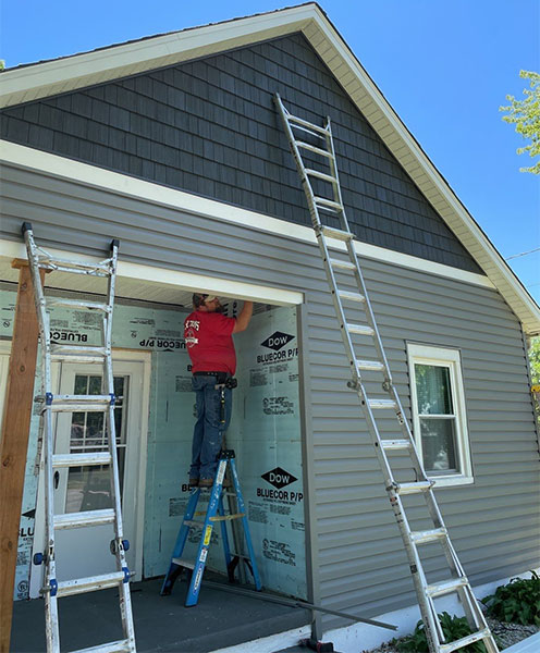 A siding specialist in Springfield, IL that is installing brand new siding on the exterior of a residential home.