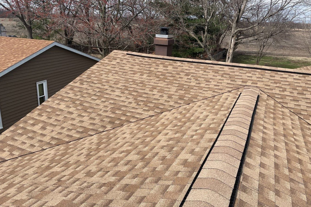 A residential roof in Springfield, IL that has had beautiful tan and brown asphalt shingles installed by a professional roofer at Sutton's.