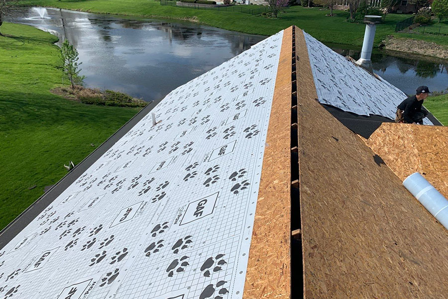A worker in the middle of a new roof installation on a residential home in Rochester, IL.