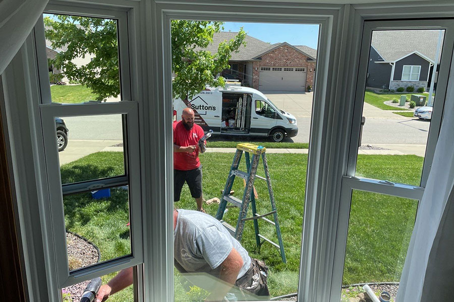 Two knowledgeable technicians from Sutton’s Inc. finish installing new replacement windows in this home in Springfield, IL.