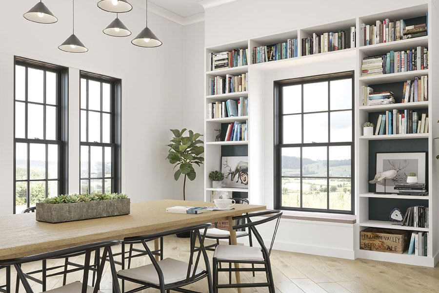A dining room decorated with a table, bookshelves, and plants receives plenty of light from several beautiful windows in a home in Chatham, IL.