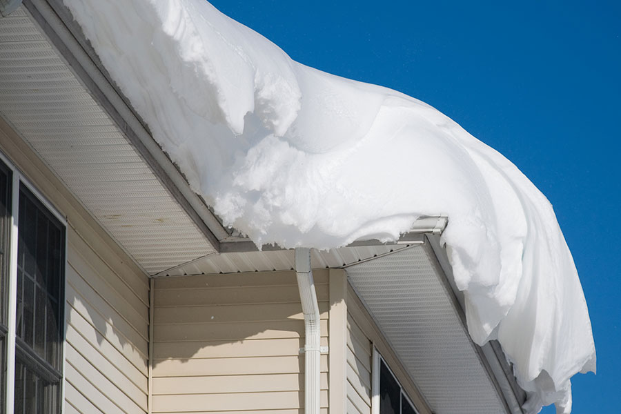Large snow drift on top of a residential roof in Springfield, IL.