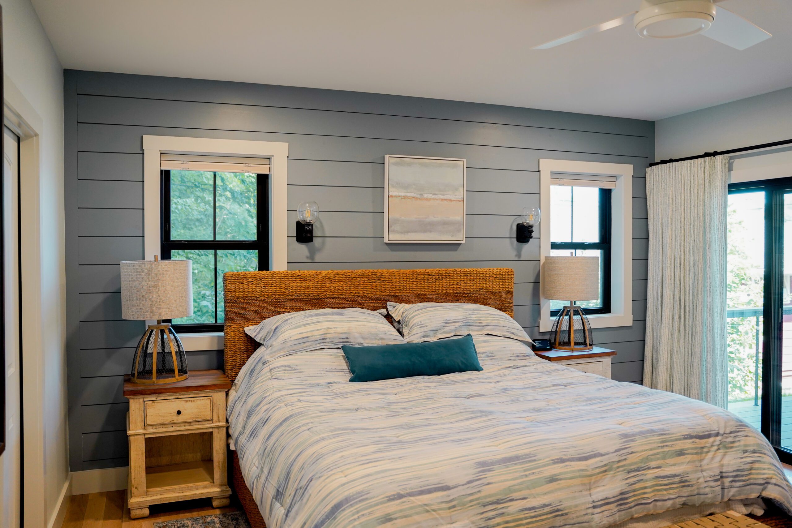 ProVia promo photo of a modern bedroom featuring black Endure double-hung windows with internal grids and wood plank accent walls – available from Sutton’s in Springfield IL