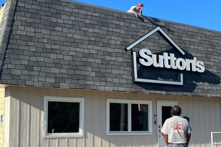 Front view of Sutton’s office in Springfield IL with two roofers talking, one on the roof and one standing on the ground
