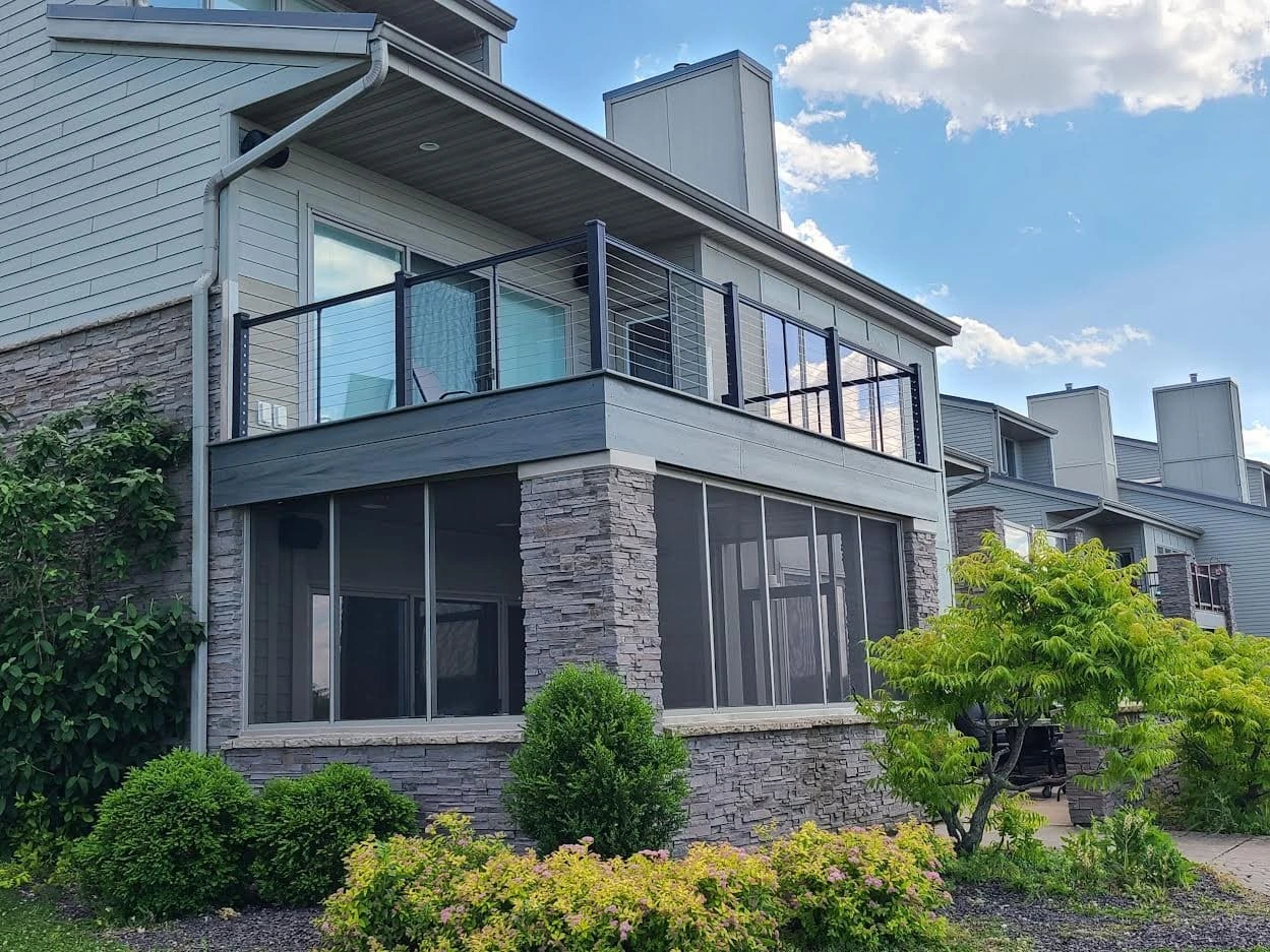 Screenroom finished by Sutton’s on a Lake Springfield townhome with a composite deck and designer railings above